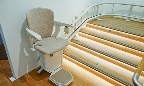 Image of curved stair lift at the top of a staircase
